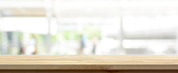 Wood table top on white blur abstract background from outdoor covered walkway in the city, panoramic banner