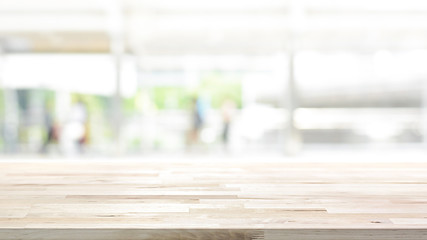 Wood table top on white blur abstract background from outdoor covered walkway in the city