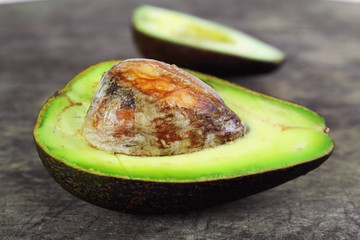 Fresh avocado on cutting board over wooden background