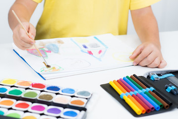 Kleiner Junge malt ein Bild mit Wasserfarben