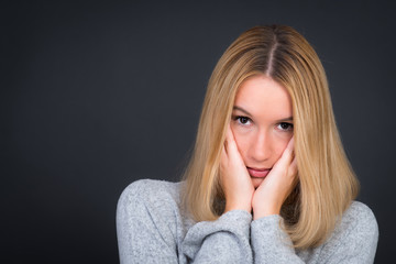 Nachdenkliche nette Frau mit Händen am Gesicht