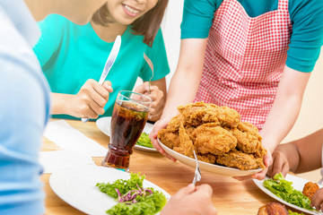 Group of young people at dining table ready to eat fried © Atstock Productions