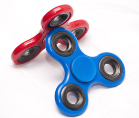 Red and blue fidget spinners leaning upon each other