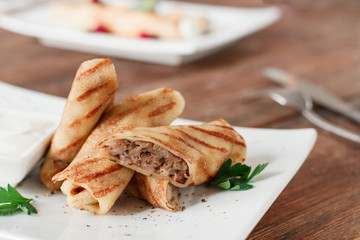 Russian pancakes with meat. Restaurant serving of healthy morning breakfast. Homemade filled by chicken crepe rolls on white plate.