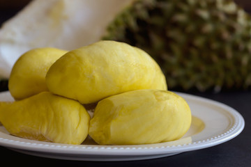 Traditional Thai fruit :Durian,the king of fruit in Thailand on white plate put on rustic wood table. Durian is tropical fruit so delicious, sweet and good smell. Ripe durian has yellow gold colour.