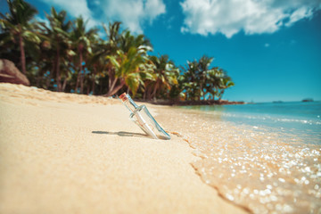 Bottle with a message on a tropical island beach