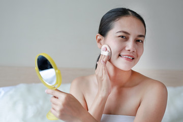 Obraz na płótnie Canvas Beauty asian woman applying makeup with Sponge Powder Puff. Woman make up herself.
