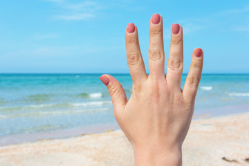 hand sign over blue sea and sky background, summer travel, holiday vacation concept background