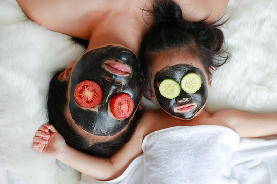Young Woman And Child Girl In Black Peeling Face Mask, Beauty Concept.