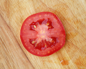Top view sliced tomato on wooden block.