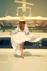 Girl in a flying dress on a yacht. Dress develops in the wind