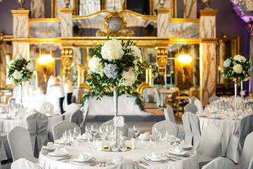 Table number seven decorated with white hydrangeas stands in the rich hall