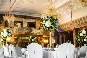 Table number eight decorated with white hydrangeas stands in the rich hall
