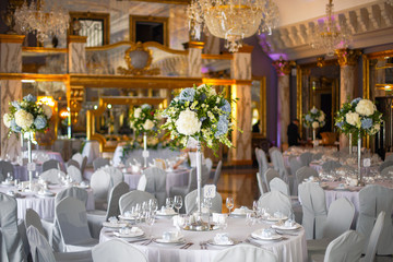 Table number eight decorated with white hydrangeas stands in the rich hall