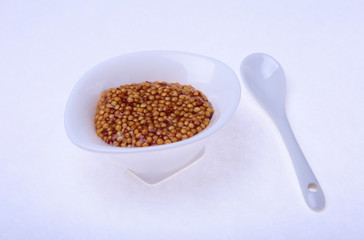Typical french dijon rough mustard in bowl from isolated on white background
