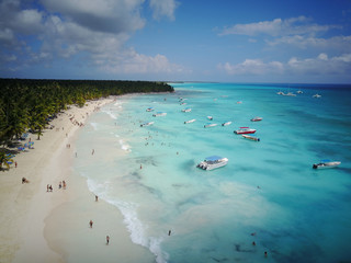 Look from above at turquoise water along golden beach somewhere in Dominican Republic