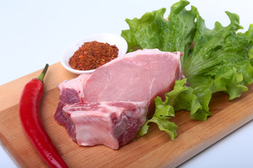 Raw pork chops with herbs and spices on cutting board. Ready for cooking.