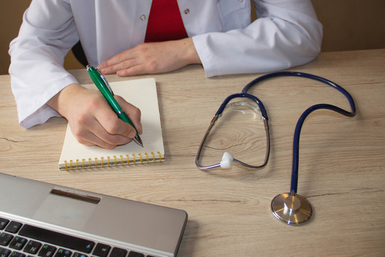 Stethoscope with clipboard and Laptop on desk. Medicine doctor's working table