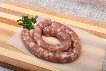 Homemade Raw sausage with spices on a wooden background.