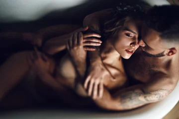Poster Man hugs woman from behind lying in the bath © IVASHstudio