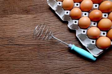 Whip eggs with eggs in a tray on wooden boards.