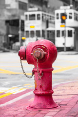 Hong Kong Street Nostalgia / Vintage red fire hydrant at Hong Kong sidewalk and two streetcars at...