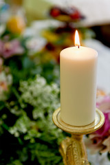 Candle in a Golden candlestick on the table of the newlyweds. Wedding floristry