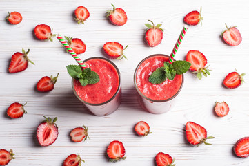 Strawberry smoothie in glass on white background. Summer drink cocktail. Healthy eating dieting and breakfast concept. Top view