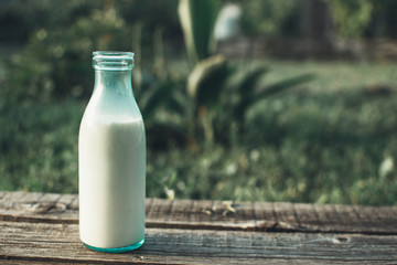 Bottle of fresh milk and glass on a wooden table