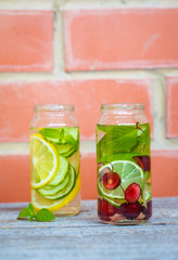 Citrus, cherry and herbs infused sassi water for detox or dieting in glass bottles. Clean eating, weight loss, healthy lifestyle concept