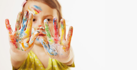 Colorful painted hands in a beautiful young girl (art, childhood, colour concept)
