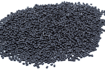 Black plastic polymer granules on white background