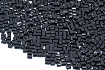 Black plastic polymer granules on white background