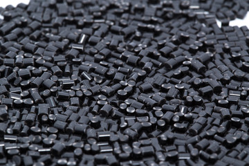 Black plastic polymer granules on white background