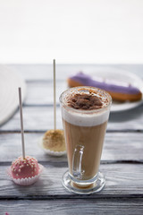 Coffee cappuccino with beautiful sweets on wooden background.Beautiful sweets