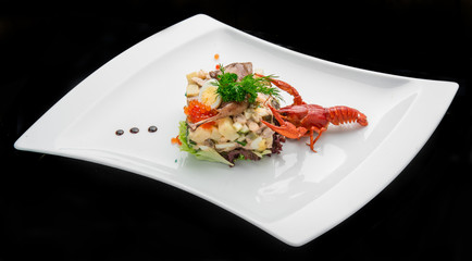 Olivier salad with trout in a white plate.