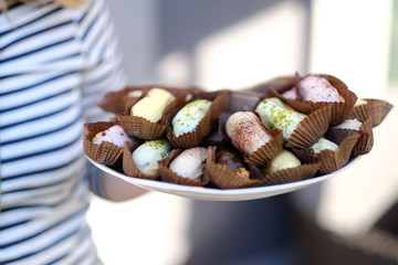 Woman holding a plate with eclairs