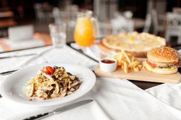 beautiful table of italian pasta, pizza, burger and drinks. selective focus