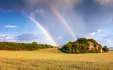 Landscape after a storm with dramatic sky and rainbow.