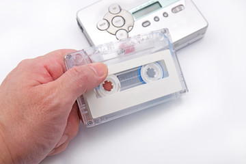Hand Holding Cassette Tape with Cassette Player Background