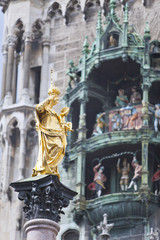 The Golden statue of Mary (Mariensaule) and dancing dolls of Town Hall at Marienplatz in Munich, Germany...