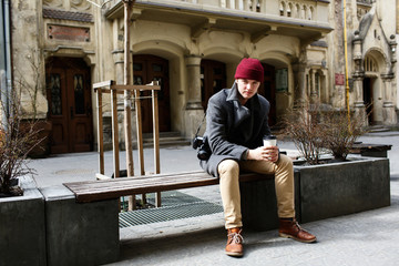 Boy in red hat sits on the bench