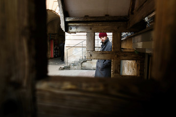 Fototapeta na wymiar Look through wooden blocks at young man in grey coat