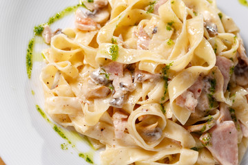 Tagliatelle pasta with ham, mushrooms and yolk. Selective focus