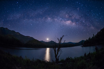 Milky Way band across sky and Moonrise over reservoir.