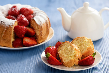 Homemade cake with strawberries on wooden background.