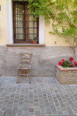 Fototapeta na wymiar Alter Stuhl vor italienischem Haus