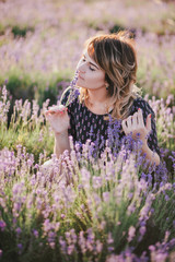 Young beautiful woman posing in a lavender field. Summer mood