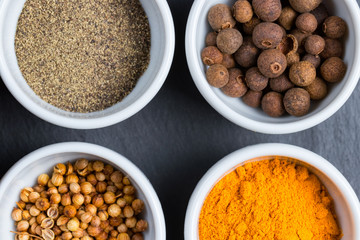 Closeup of fresh colorful spices in white bowls.