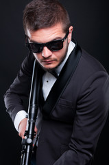Mafia guy with armed rifle preparing to shoot